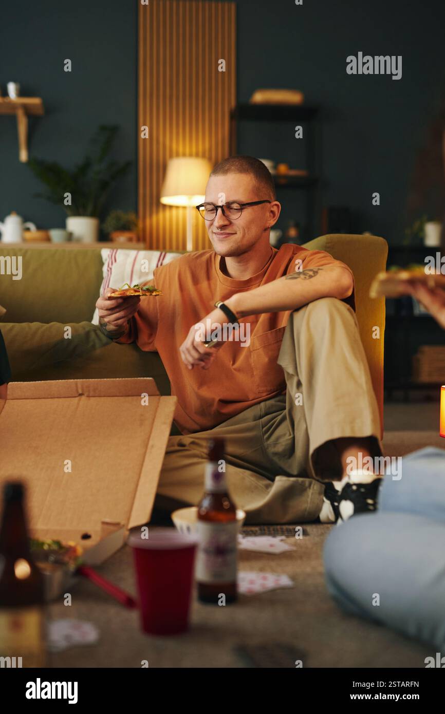 Genießen Sie die abendliche Pizza mit Freunden im gemütlichen Wohnzimmer Stockfoto