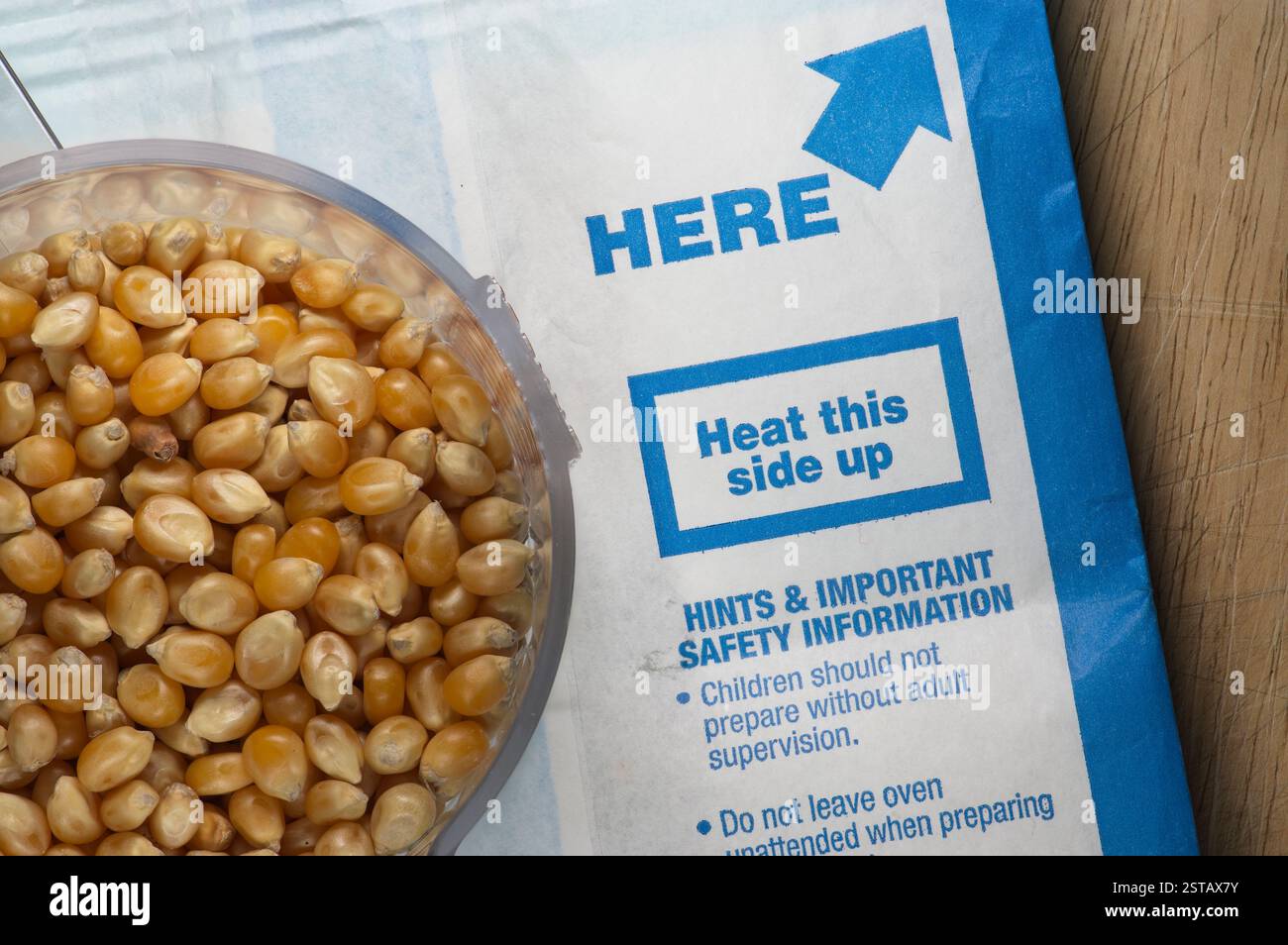 Eine Tasse Popcorn sitzt auf einem Mikrowellen-Popcorn-Beutel Stockfoto