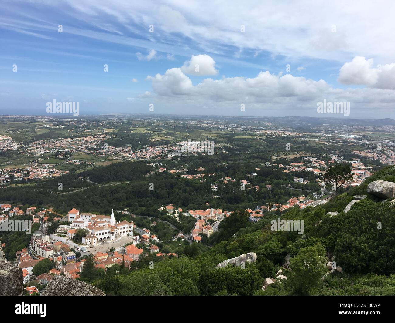 Panoramablick auf Sintra, Portugal. Üppige grüne Hügel mit Villen. Nationalpalast von Pena in der Ferne. Eine märchenhafte Landschaft. Sintra, Portu Stockfoto