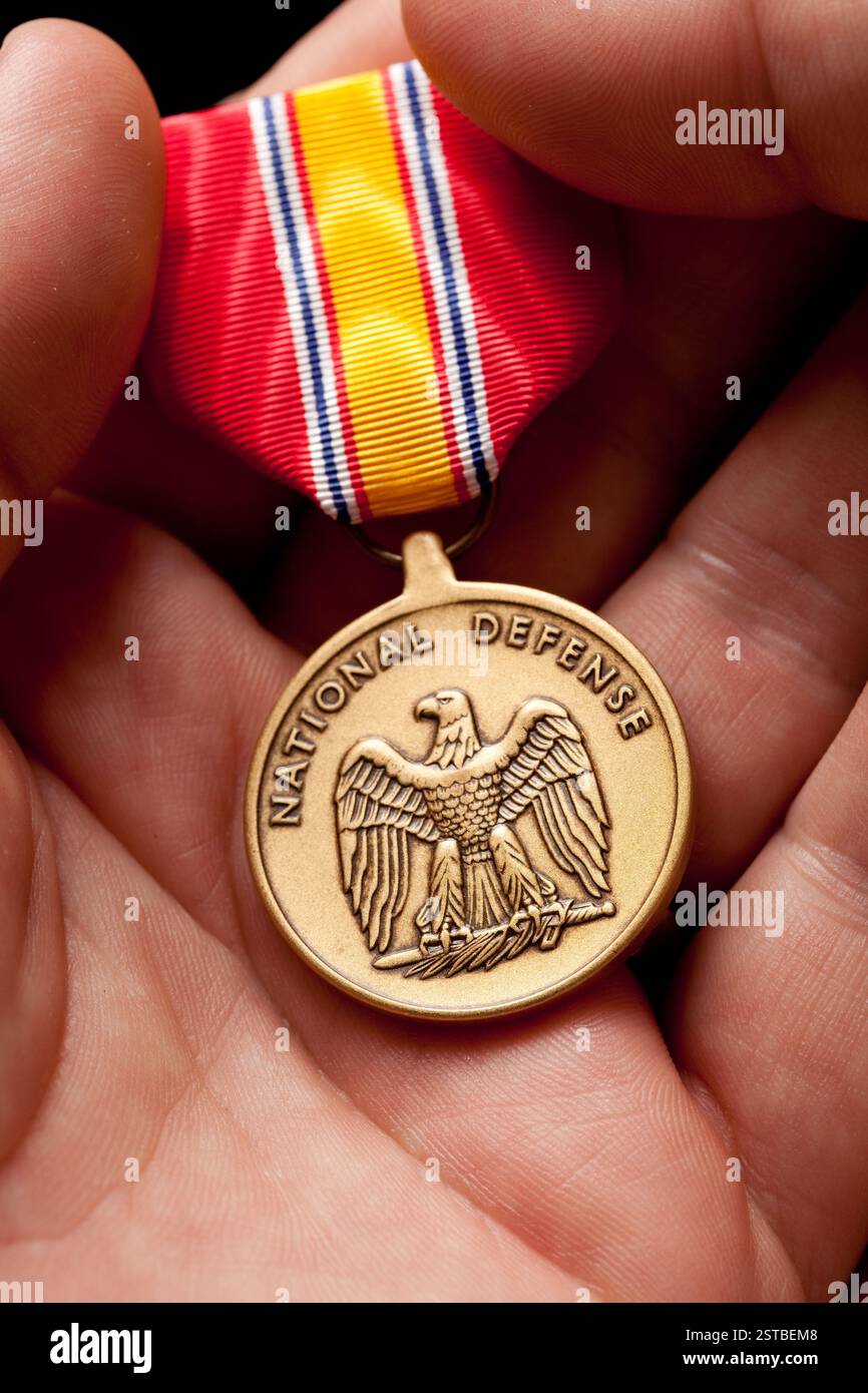 Ein Mann, der die National Defense war Medaille in der Hand hält. Stockfoto