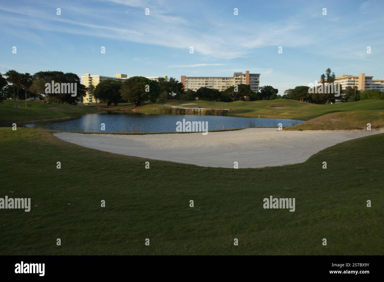 Ein Golfparadies erwartet Sie in Miami. Das üppig grüne Fairway erstreckt sich in Richtung eines unberührten Sandbunkers mit einem luxuriösen Hotel in der Nähe Stockfoto