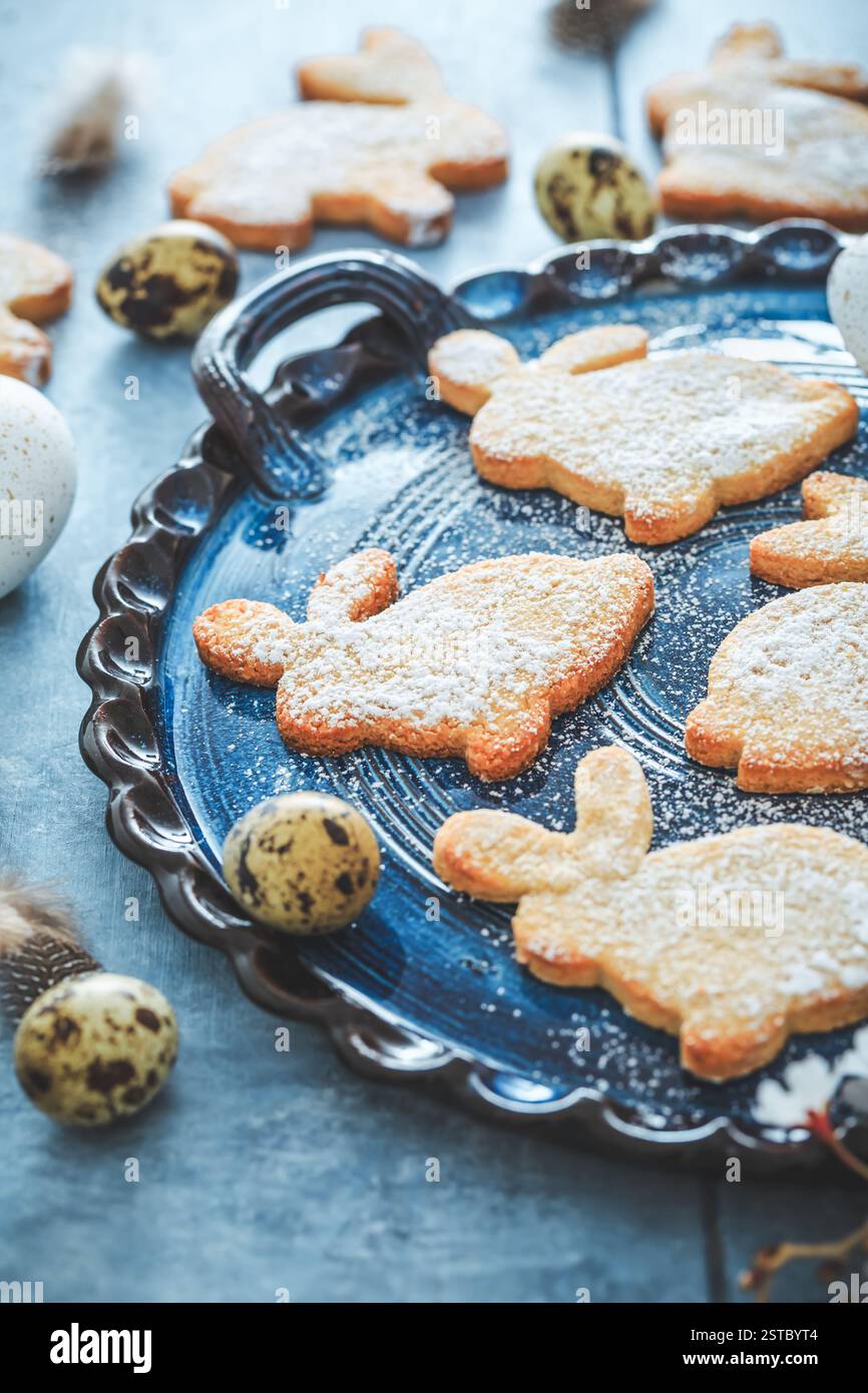 Hausgemachte Mandelhasen-Kekse zu Ostern mit Ostereiern in Blauton Stockfoto