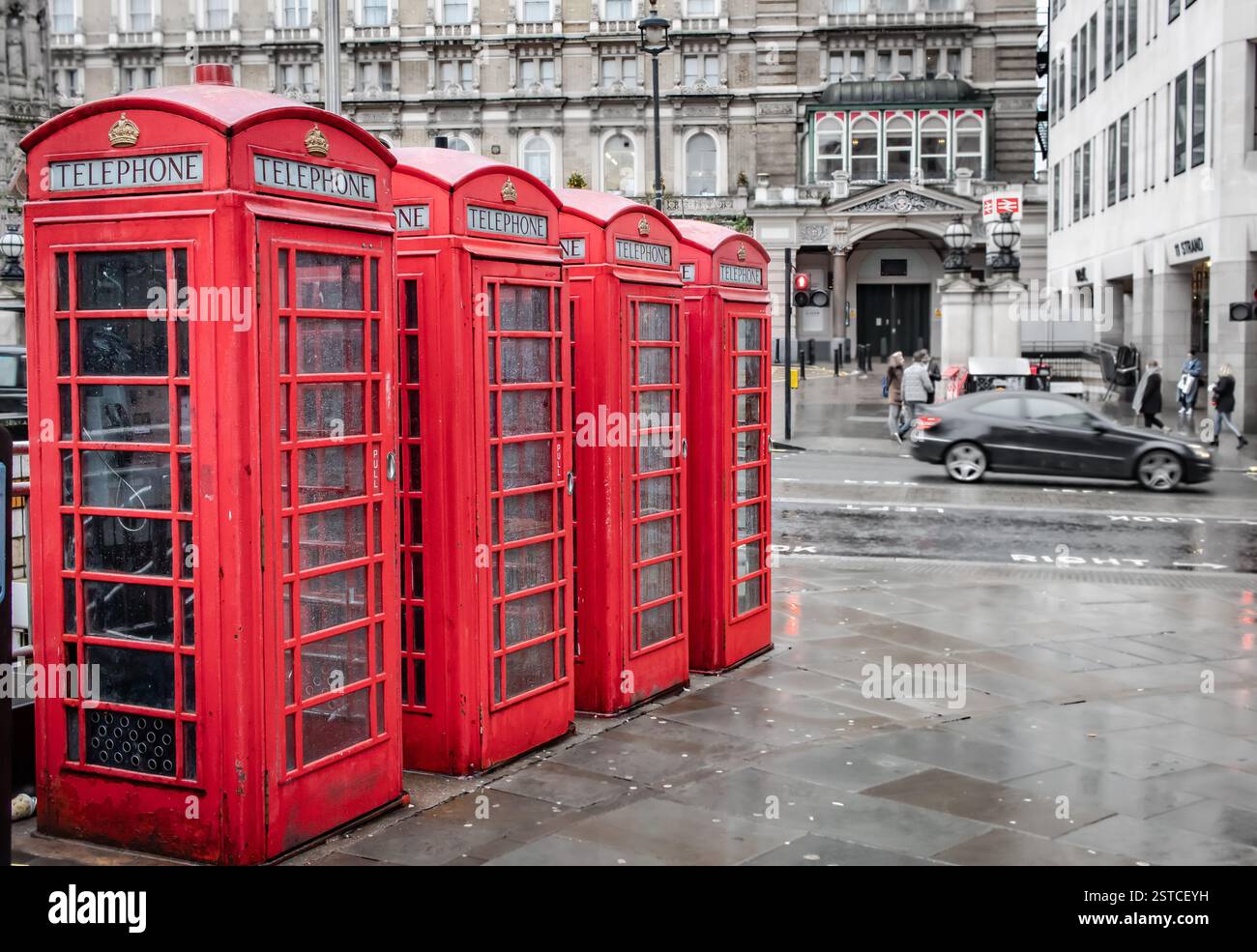 Rote Vintage-Londoner Telefonzellen, die entlang einer Straße in der Innenstadt von London aufgereiht sind. Foto in London, Großbritannien Stockfoto
