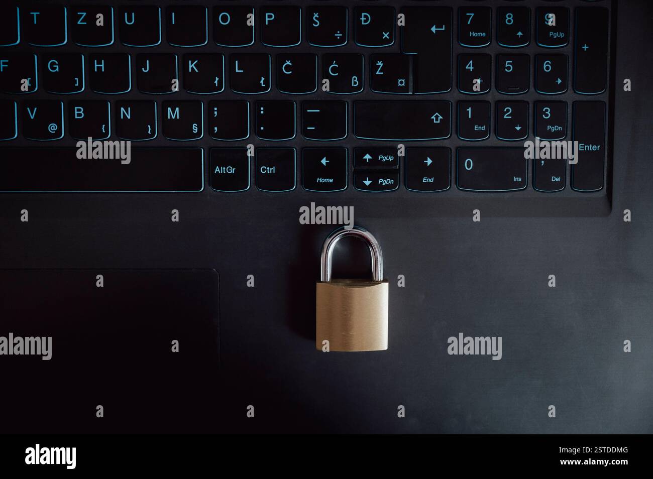 Ein goldenes Vorhängeschloss befindet sich auf einer schwarzen Laptop-Tastatur und symbolisiert Online-Sicherheit, Datenschutz und digitale Privatsphäre in der modernen Welt. Stockfoto