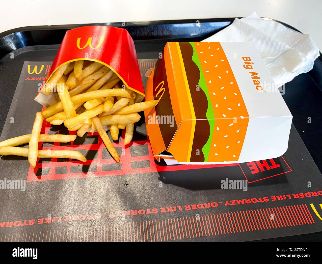 Nahaufnahme einer mittelgroßen Portion McDonalds Pommes und eines Big Mac Hamburger zum Mittagessen - Smartphone-aufgenommenes Stockfoto