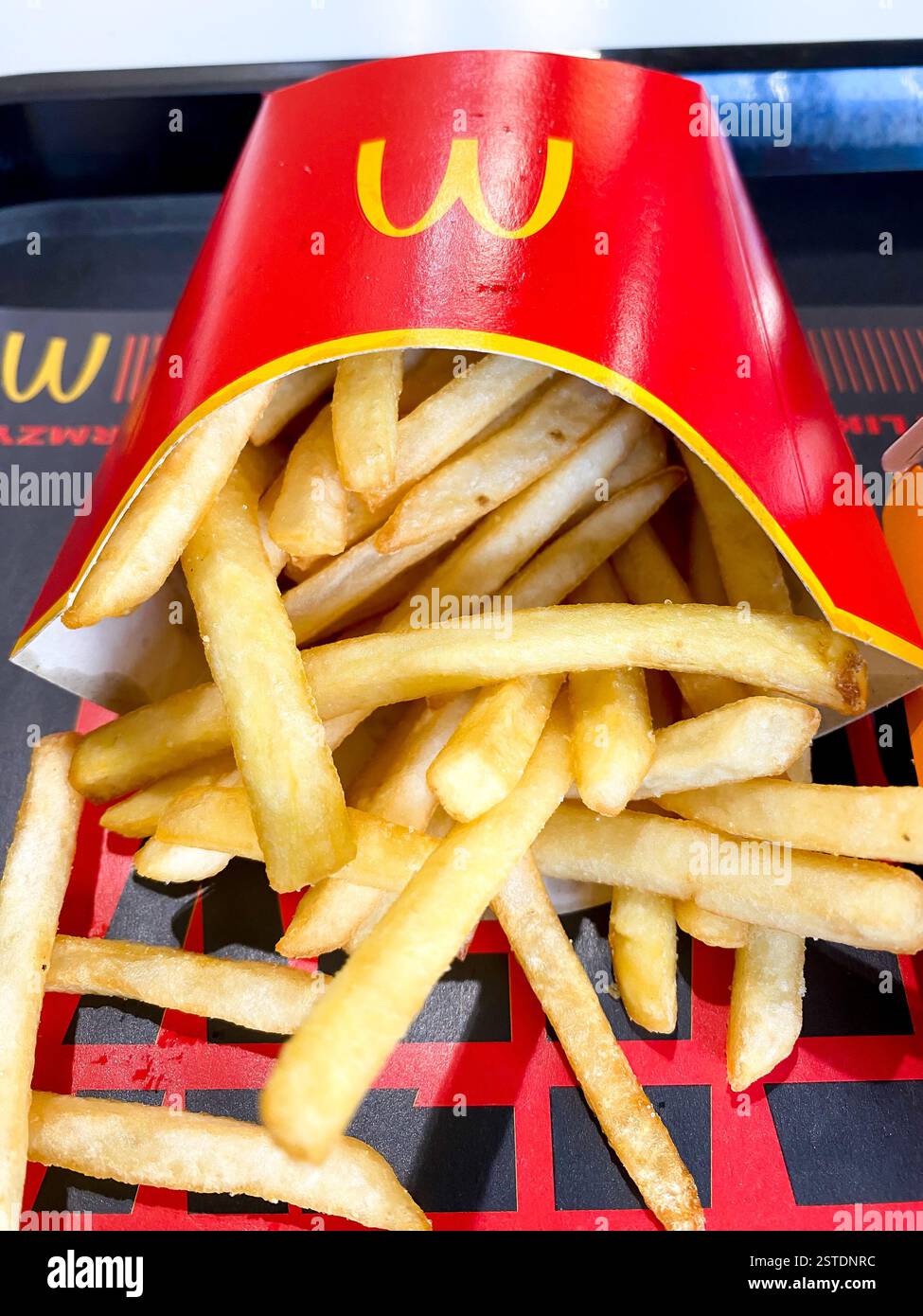 Nahaufnahme einer mittelgroßen Portion McDonald's Pommes zum Mittagessen - Smartphone-aufgenommenes Stockfoto
