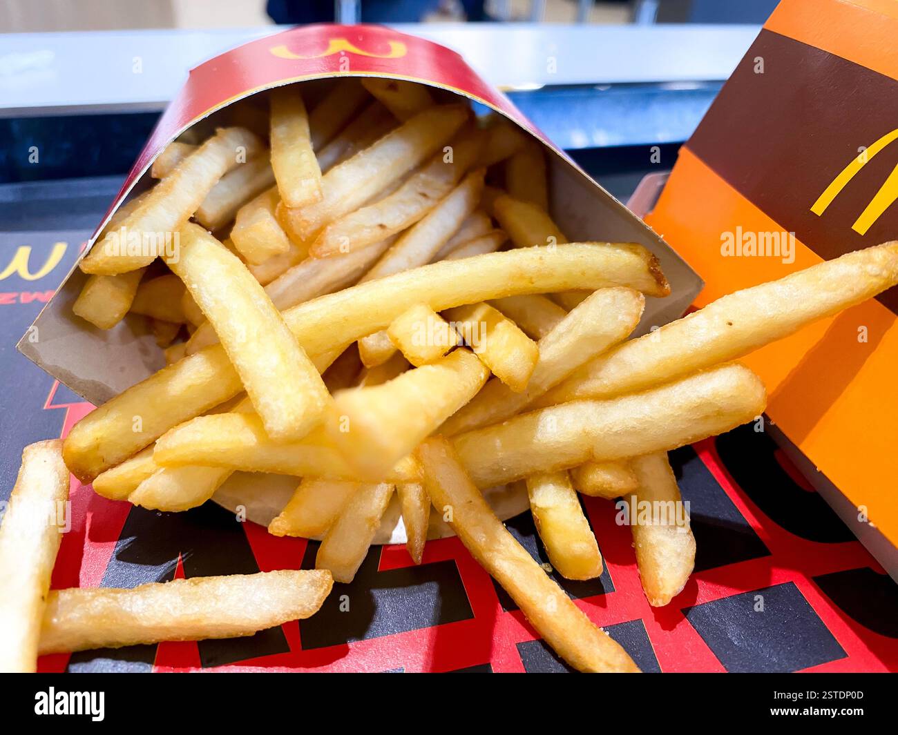 Nahaufnahme einer mittelgroßen Portion McDonald's Pommes zum Mittagessen - Smartphone-aufgenommenes Stockfoto