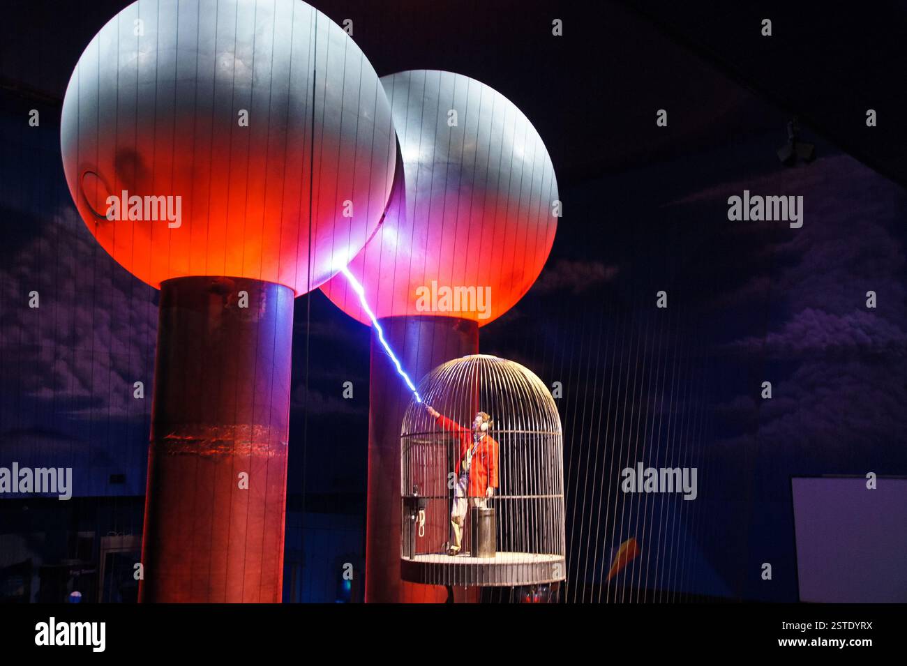 Tesla Coil Show in Boston. Elektrische Funken fliegen zwischen riesigen Kugeln. Eine Person steht sicher in einem Faraday-Käfig. Ein mächtiges und geheimnisvolles Symbol o Stockfoto