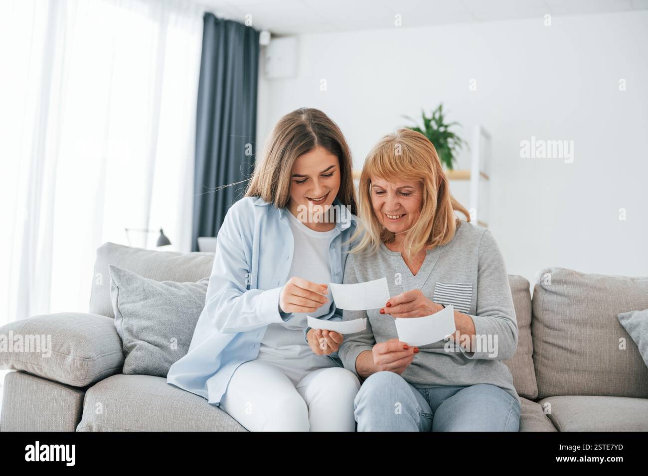 Alte Fotos ansehen. Mutter und Tochter sind zu Hause zusammen. Stockfoto