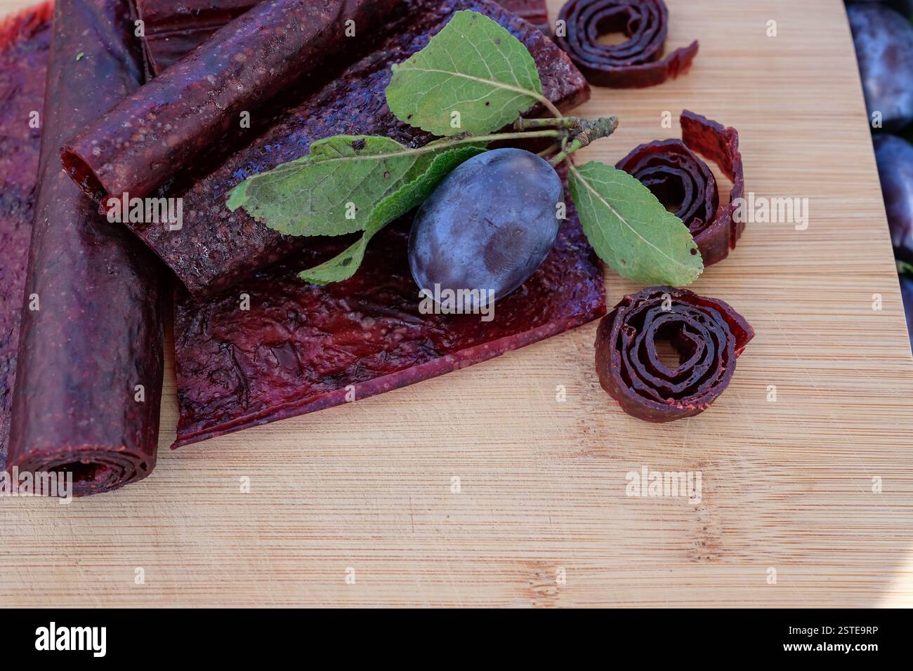 Obstleder und Brötchen. Hausgemachte oder handgemachte Pastille auf dem Holzbrett. Stockfoto