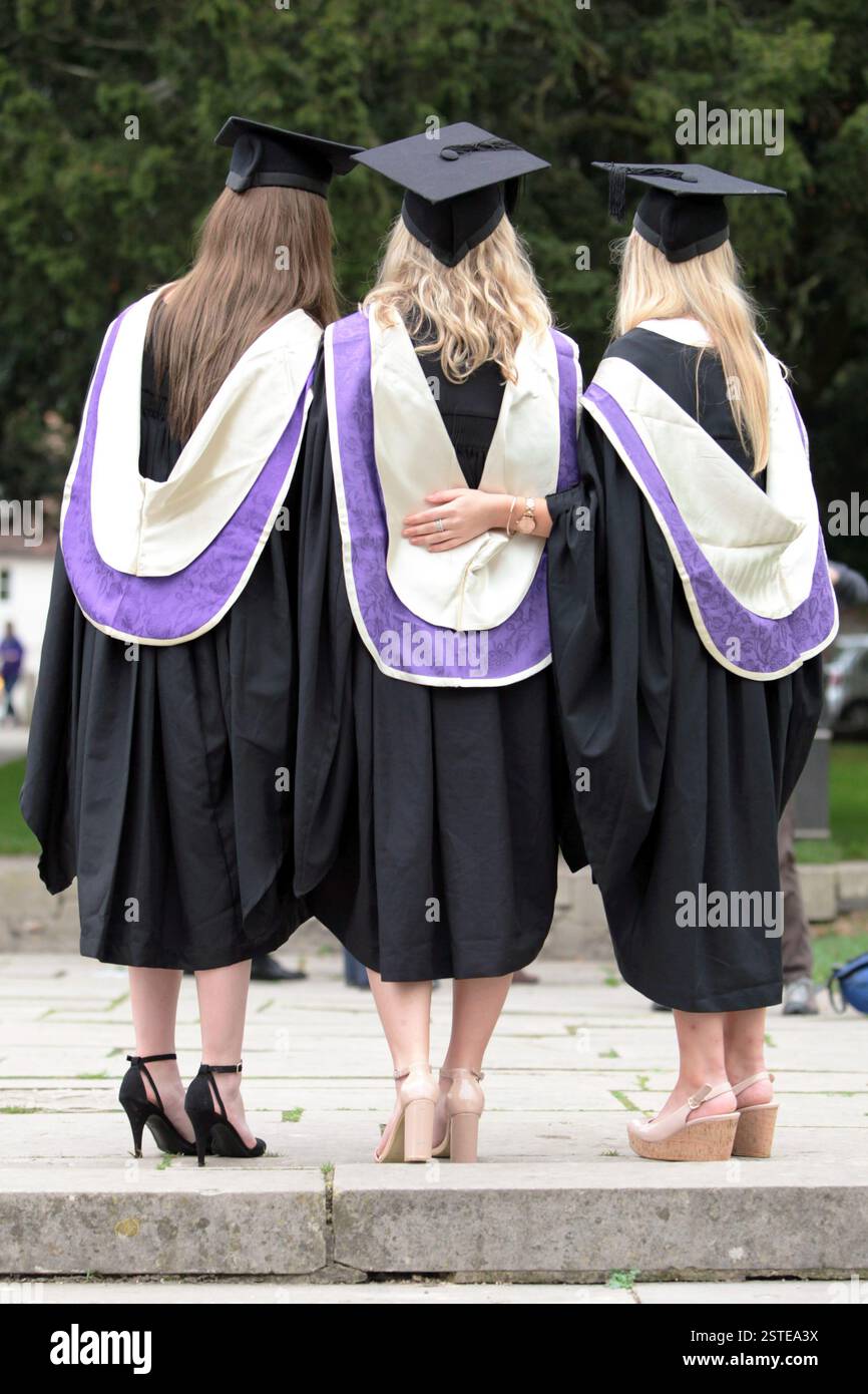 Drei junge Frauen in Kleidern, die gerade die Universität abgeschlossen haben. Winchester. UK. Stockfoto
