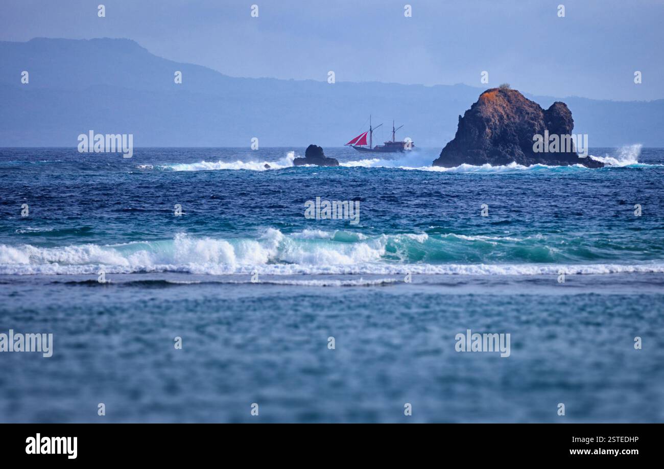 Ein alter Zweimast-Schoner in der Nähe der Felsen im Meer. Indonesien, Bali Stockfoto