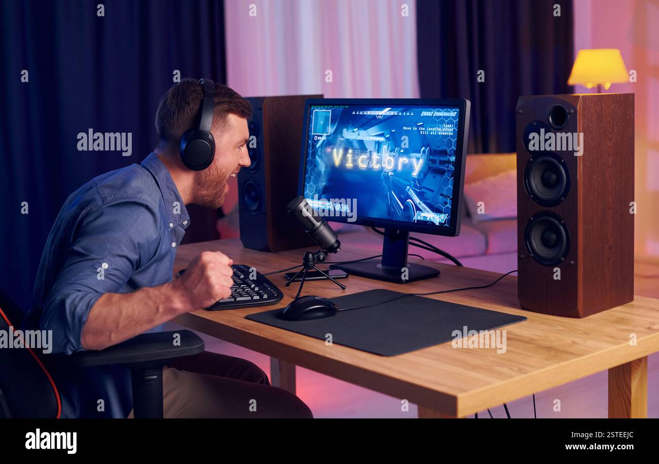 Feiert den Sieg. Online-Streamer, der FPS-Shooter zu Hause spielt. Stockfoto