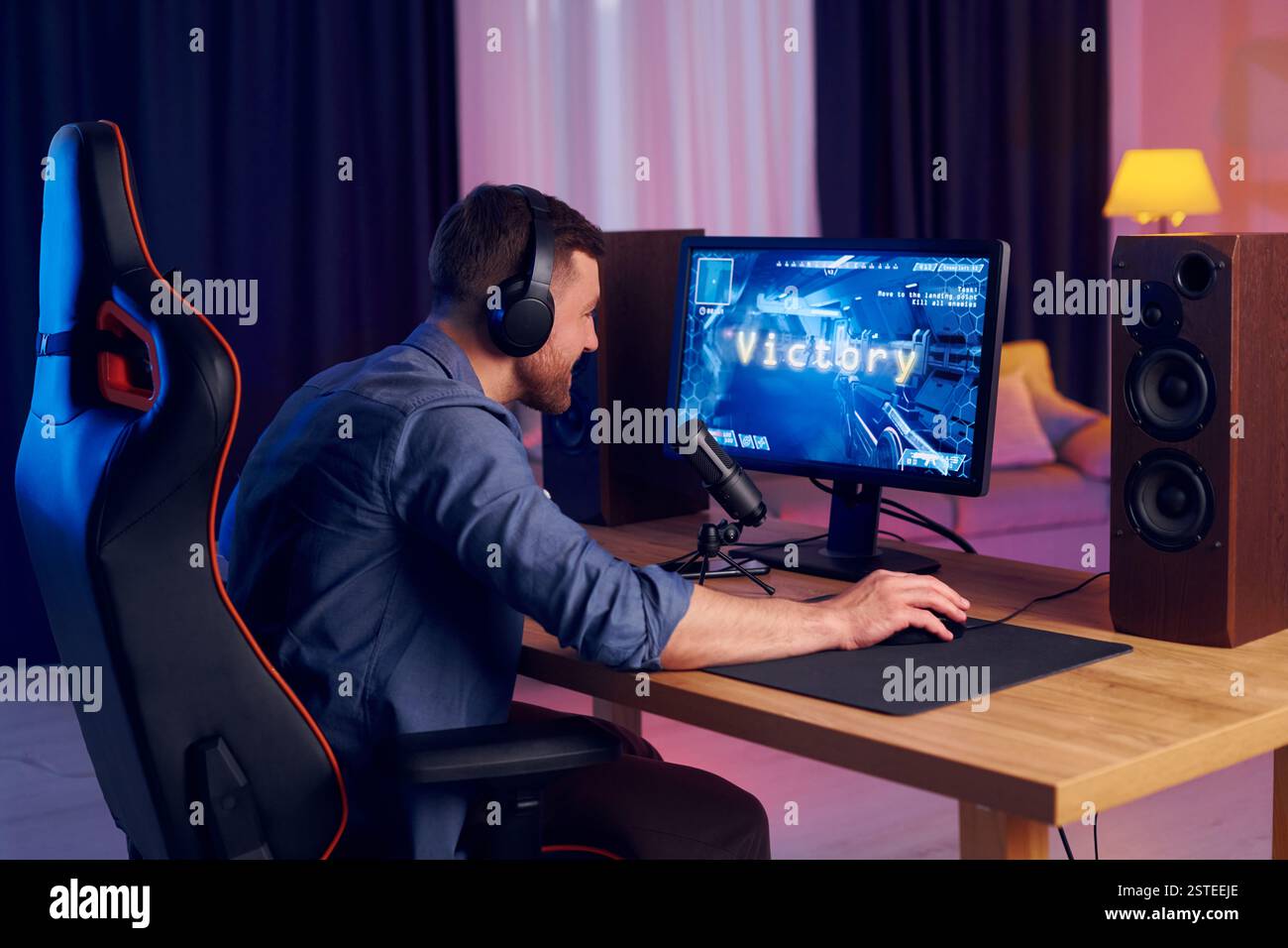 Feiert den Sieg. Online-Streamer, der FPS-Shooter zu Hause spielt. Stockfoto