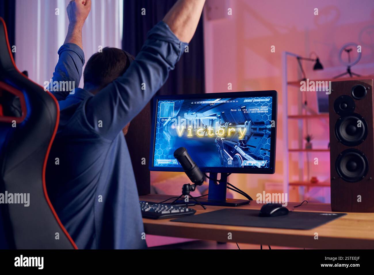 Feiert den Sieg. Online-Streamer, der FPS-Shooter zu Hause spielt. Stockfoto