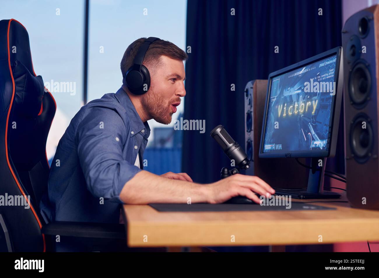 Konzentriert auf das Spielen. Man streamt FPS-Shooter-Spiel zu Hause. Stockfoto