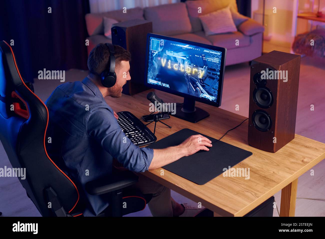 Konzentriert auf das Spielen. Man streamt FPS-Shooter-Spiel zu Hause. Stockfoto
