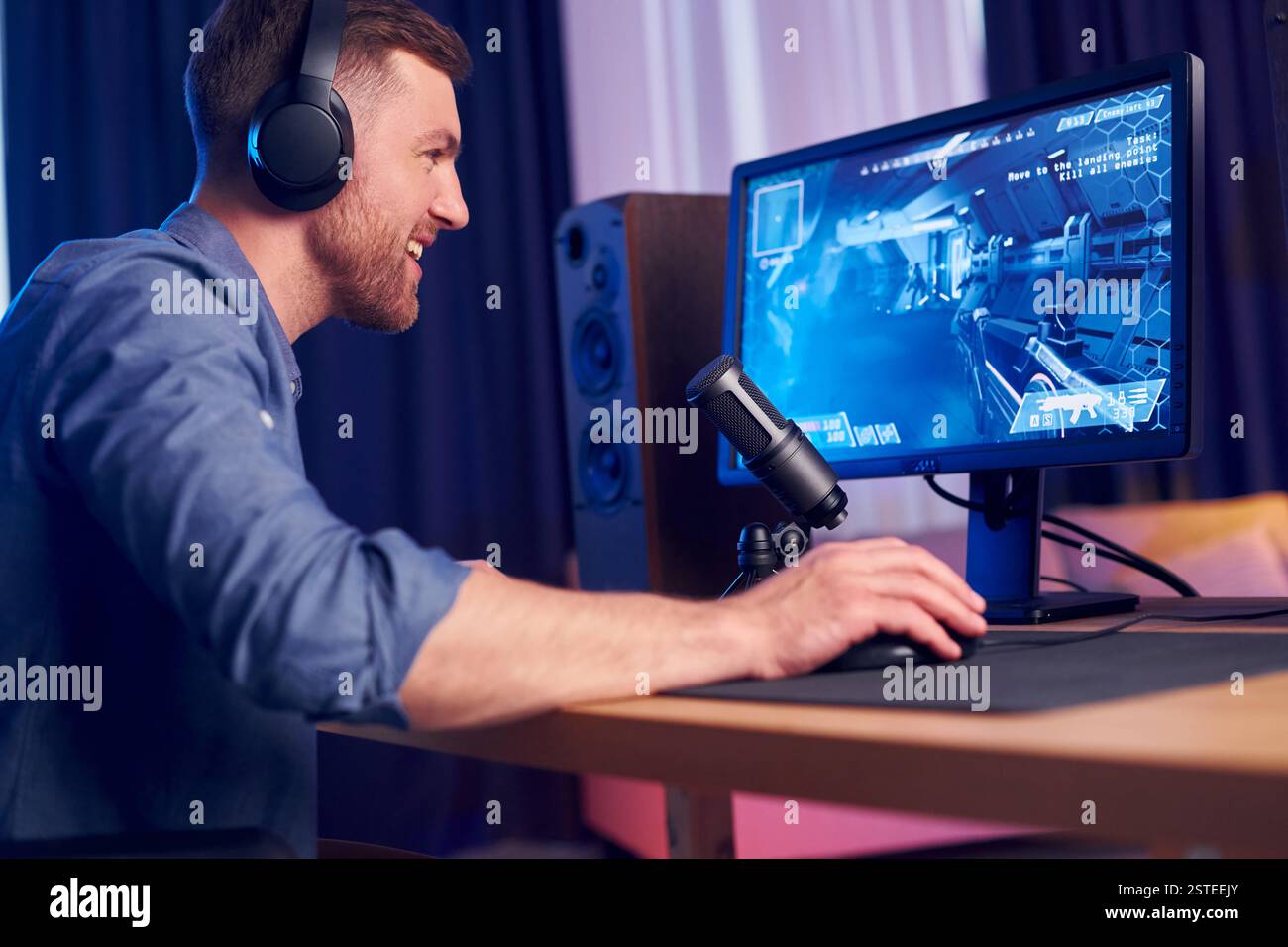 Konzentriert auf das Spielen. Man streamt FPS-Shooter-Spiel zu Hause. Stockfoto
