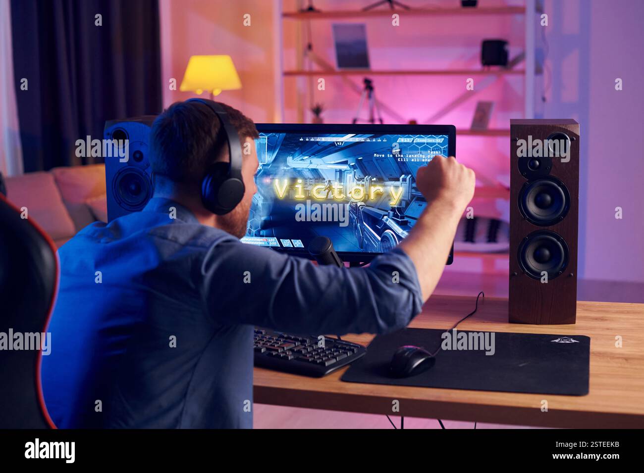 Der Mann gewinnt dieses Spiel. Online-Streamer spielt FPS-Shooter zu Hause. Stockfoto