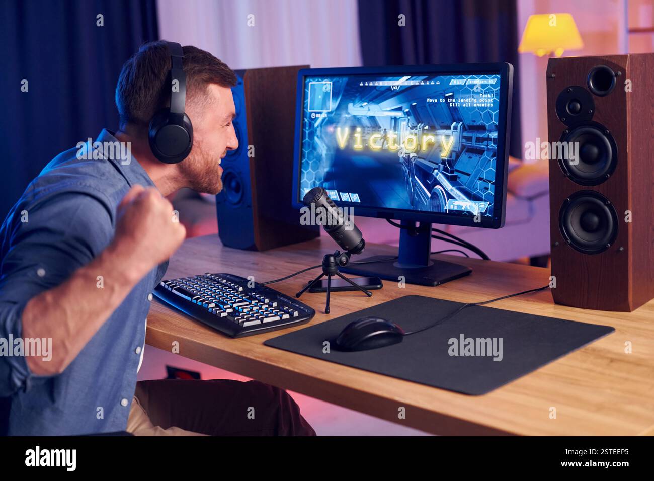 Feiert den Sieg. Online-Streamer, der FPS-Shooter zu Hause spielt. Stockfoto