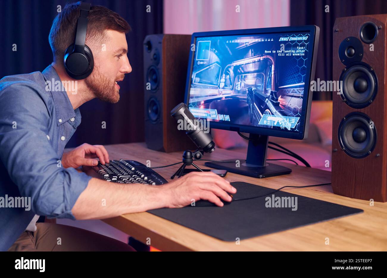 Konzentriert auf das Spielen. Man streamt FPS-Shooter-Spiel zu Hause. Stockfoto