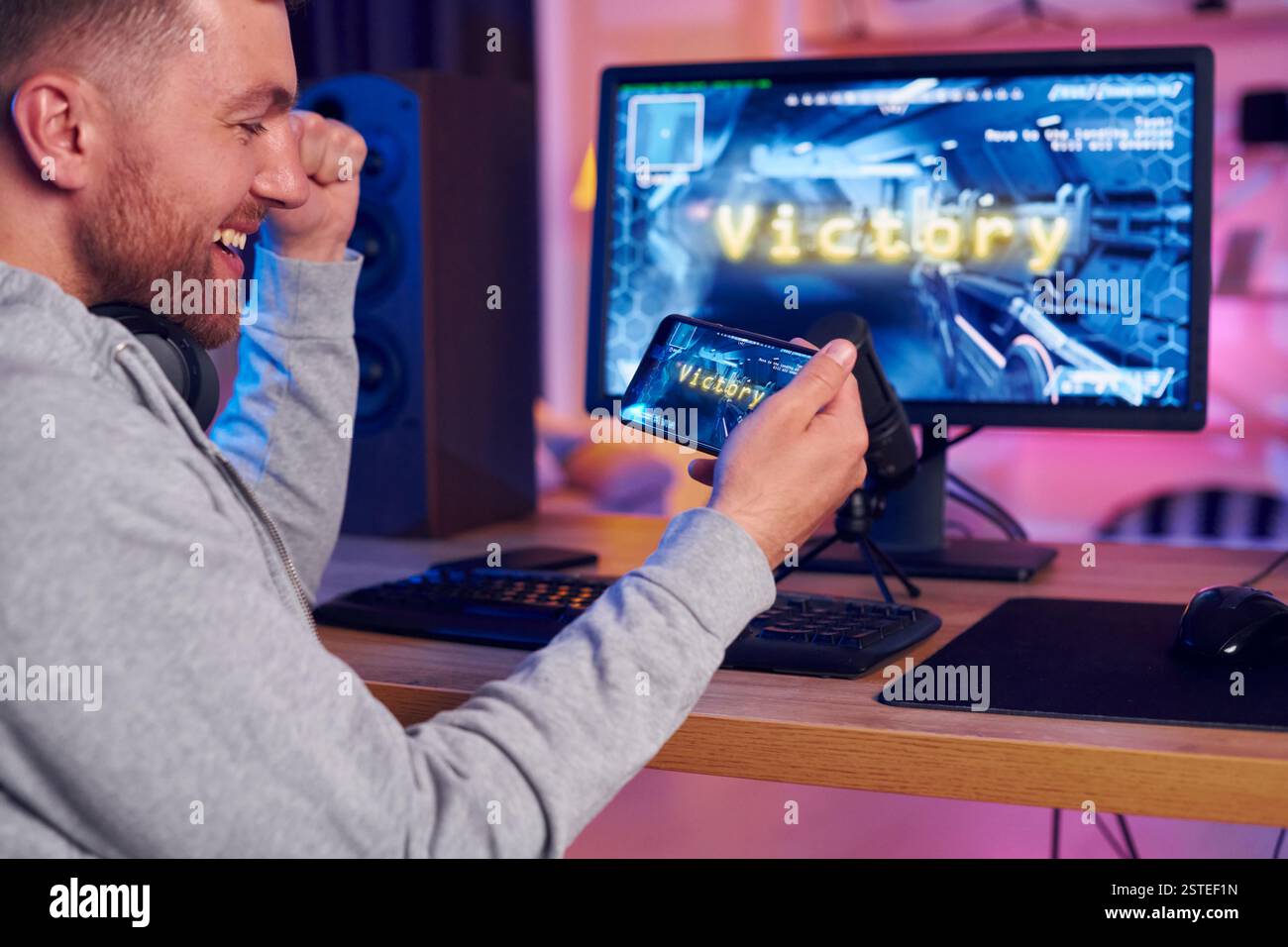 Feiert den Sieg. Online-Streamer, der FPS-Shooter zu Hause spielt. Stockfoto