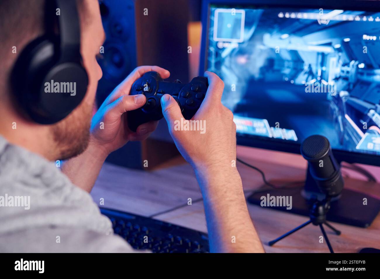 Mit dem Joystick. Online-Streamer, der FPS-Shooter zu Hause spielt. Stockfoto