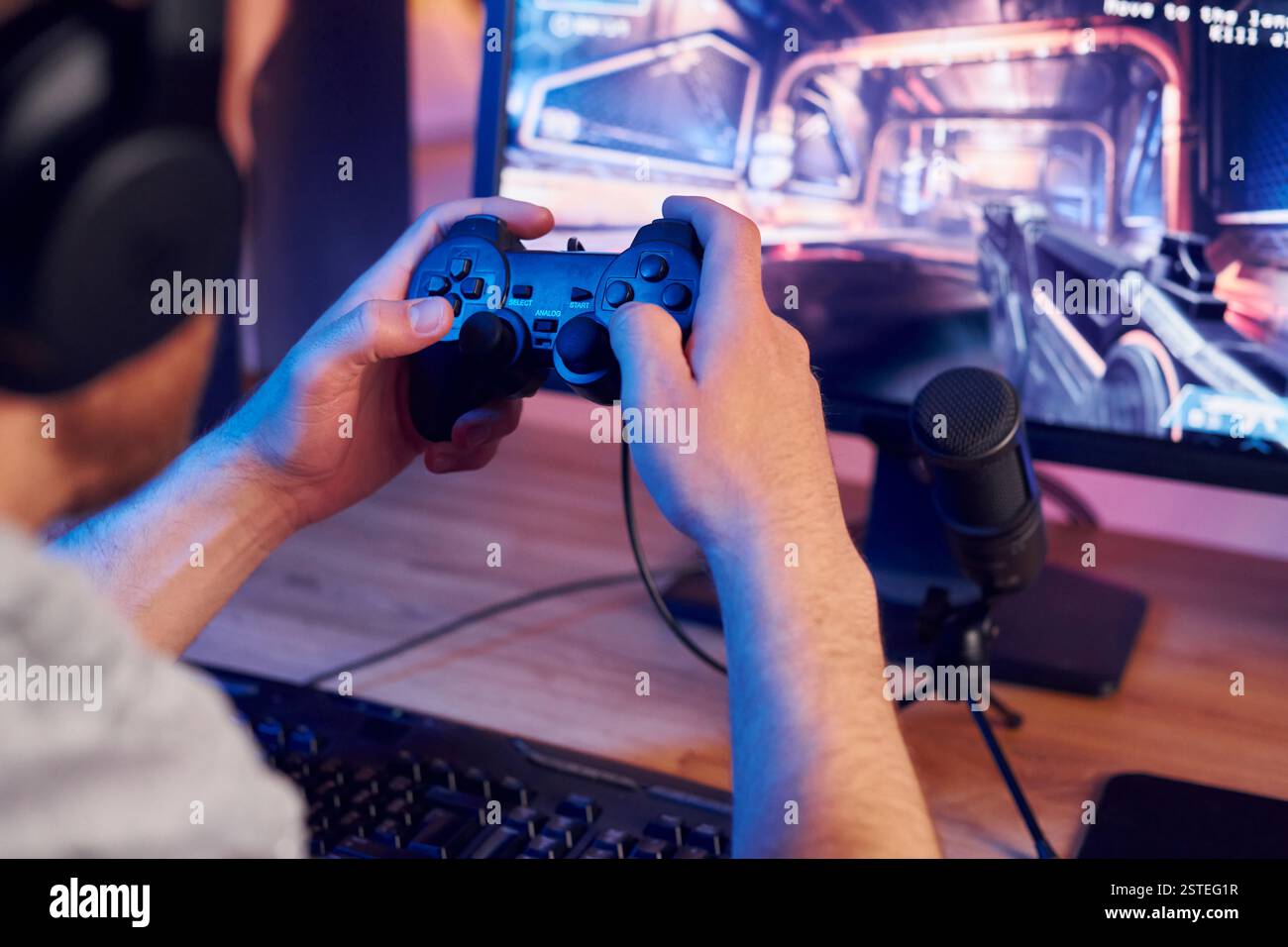 Mit dem Joystick. Online-Streamer, der FPS-Shooter zu Hause spielt. Stockfoto