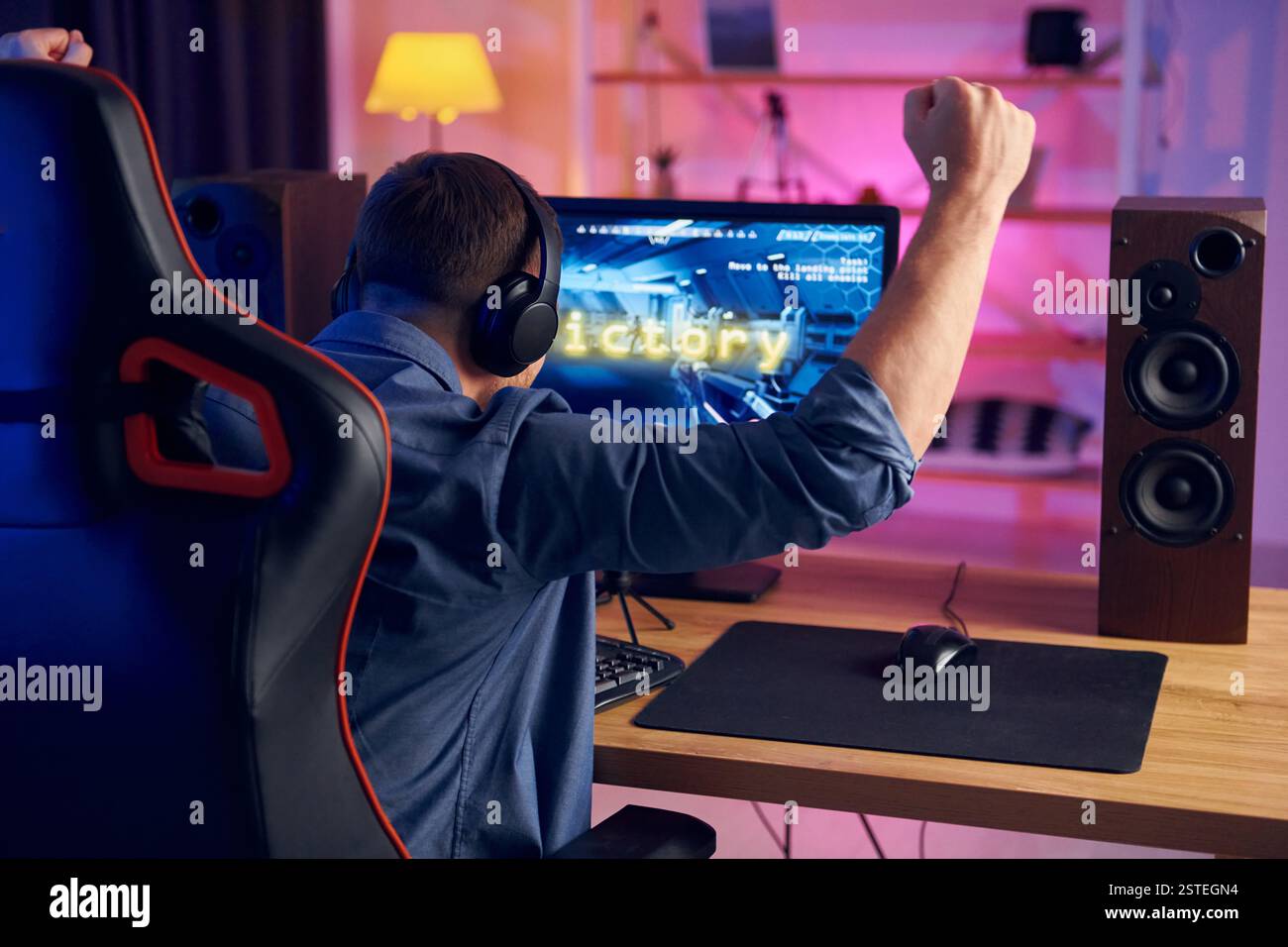 Der Mann gewinnt dieses Spiel. Online-Streamer spielt FPS-Shooter zu Hause. Stockfoto