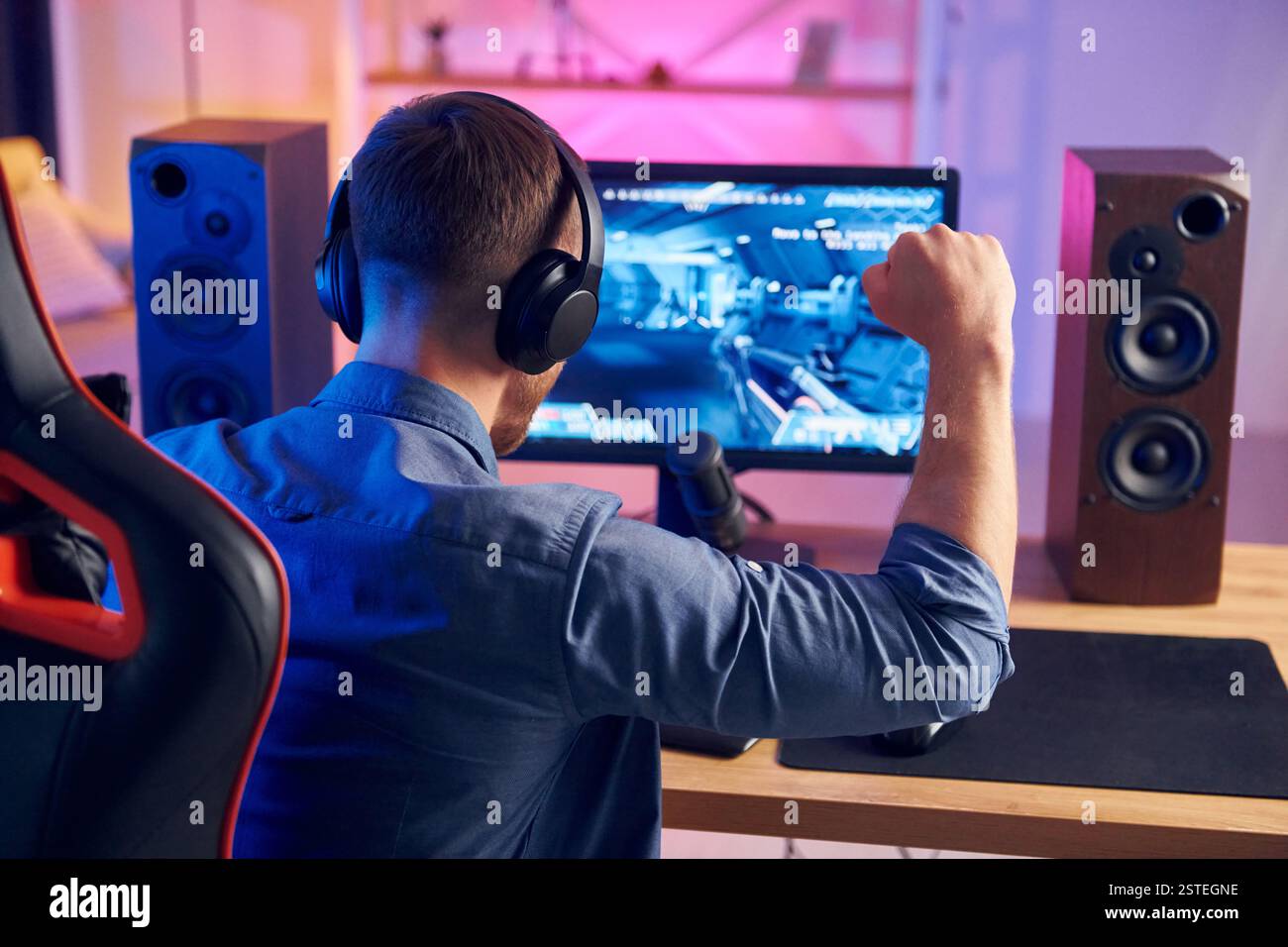 Schöner Spielstuhl. Online-Streamer spielt FPS-Shooter zu Hause. Stockfoto