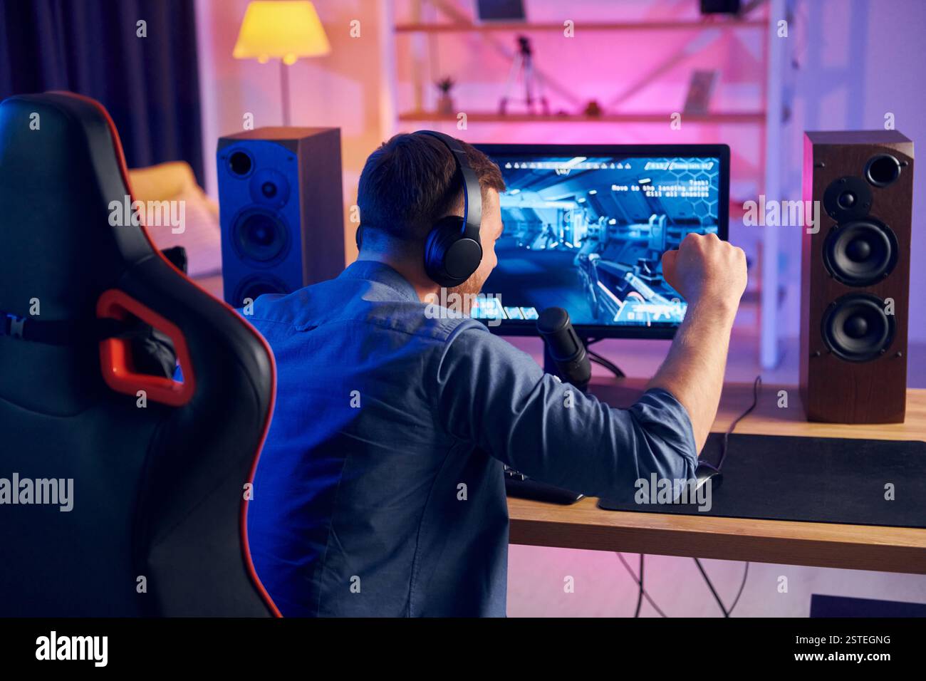 Schöner Spielstuhl. Online-Streamer spielt FPS-Shooter zu Hause. Stockfoto