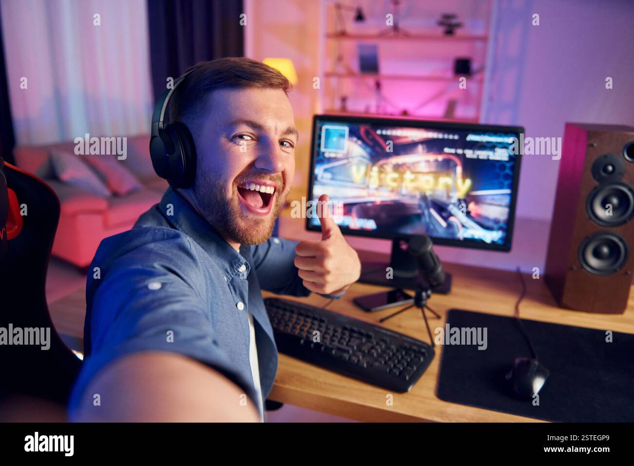 Selfie machen. Schreiend und feiert den Sieg. Online-Streamer, der FPS-Shooter zu Hause spielt. Stockfoto