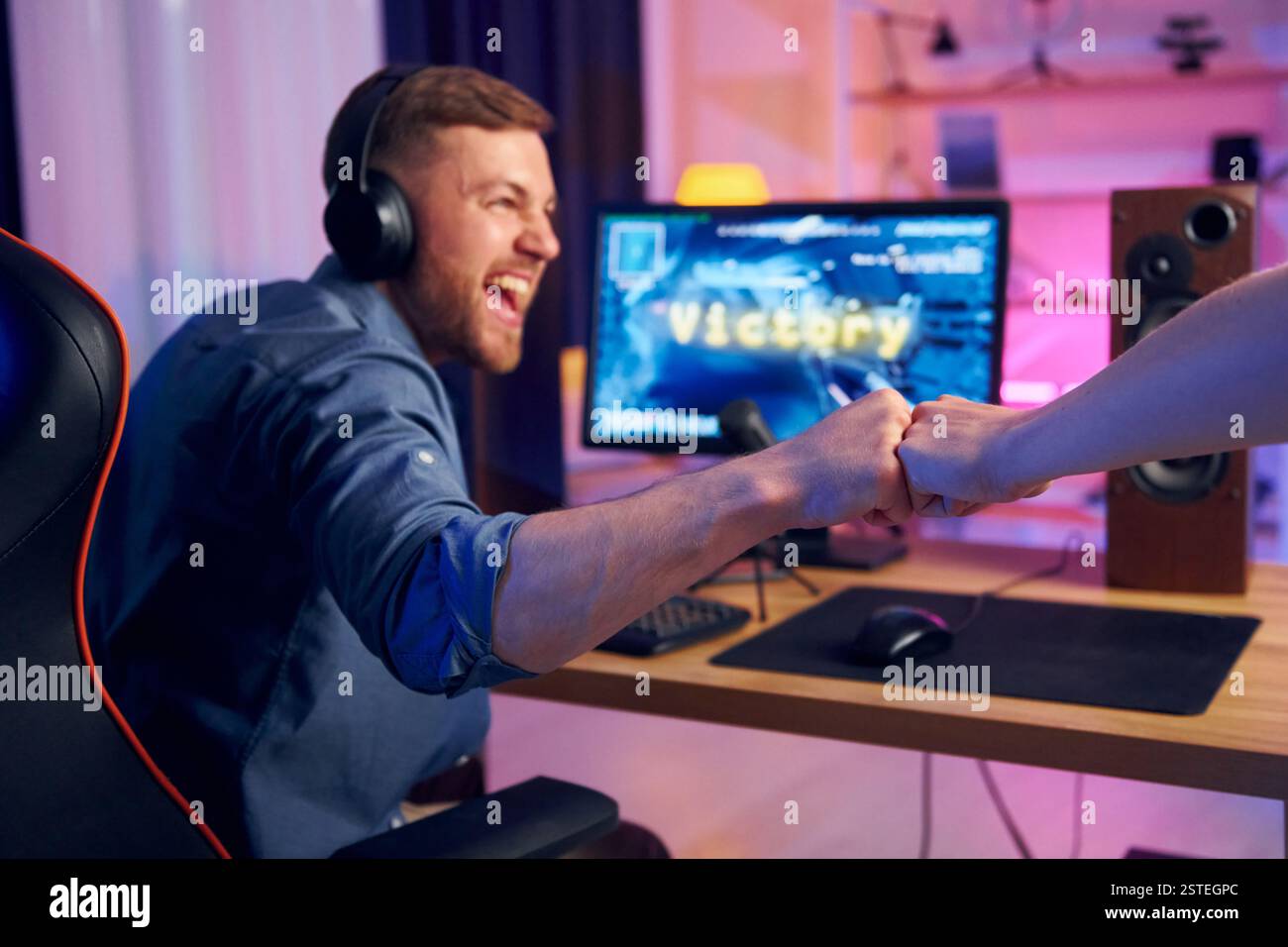 Gutes Teamplay. Online-Streamer, der FPS-Shooter zu Hause spielt. Stockfoto