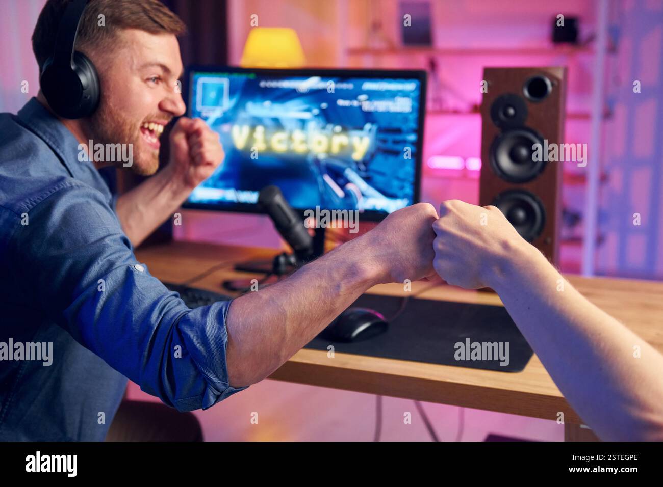 Gutes Teamplay. Online-Streamer, der FPS-Shooter zu Hause spielt. Stockfoto