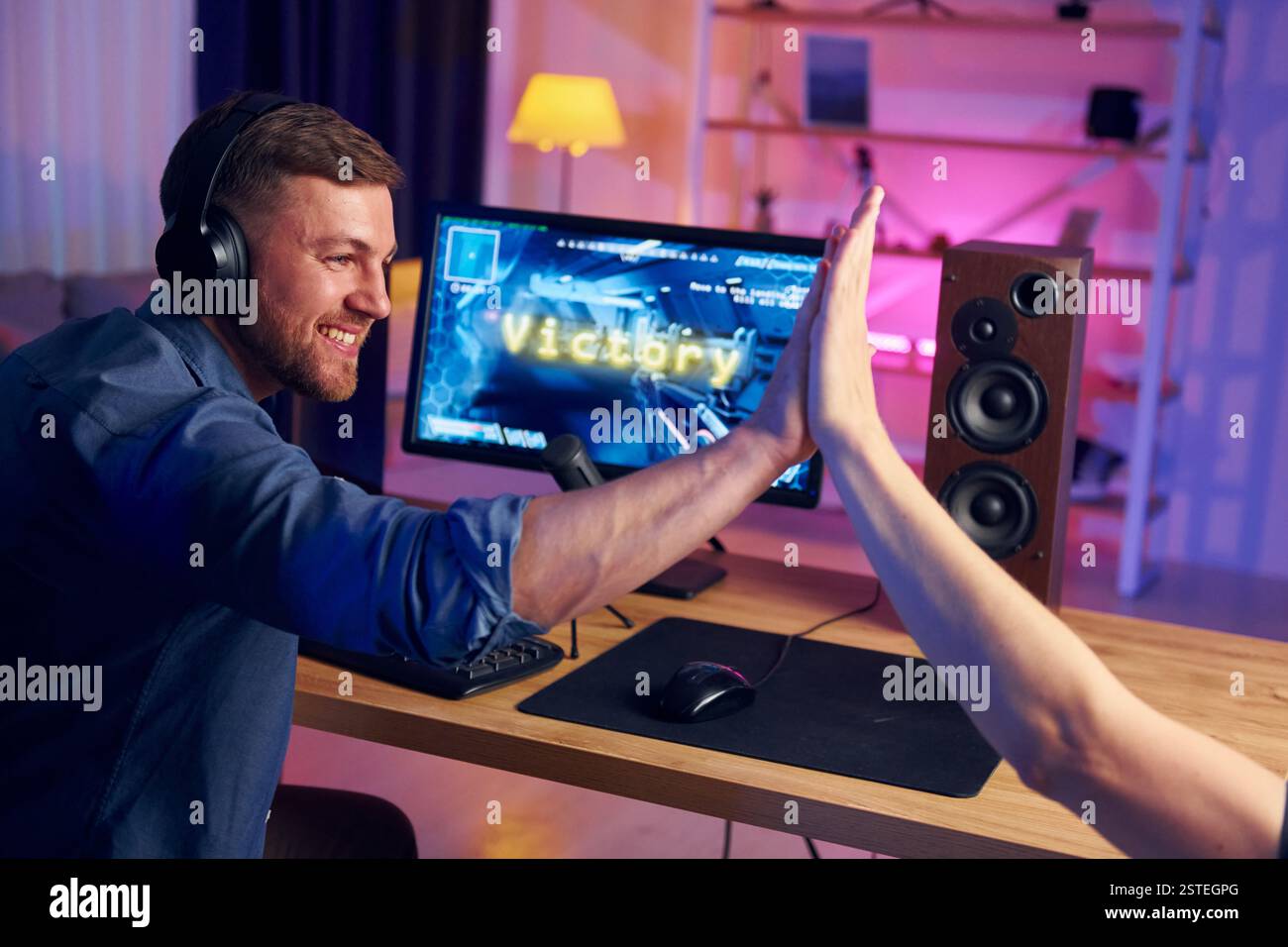 Gutes Teamplay. Online-Streamer, der FPS-Shooter zu Hause spielt. Stockfoto