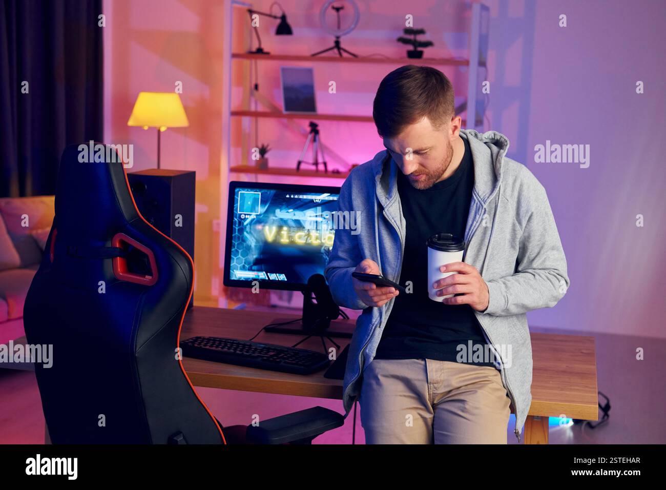 Eine Pause machen. Online-Streamer, der FPS-Shooter zu Hause spielt. Stockfoto