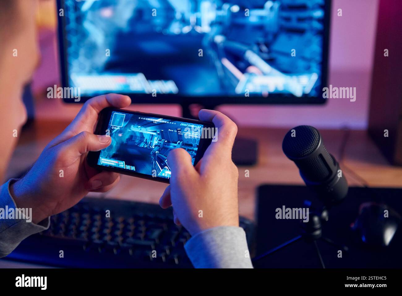 Verwenden des Smartphones. Online-Streamer, der FPS-Shooter zu Hause spielt. Stockfoto