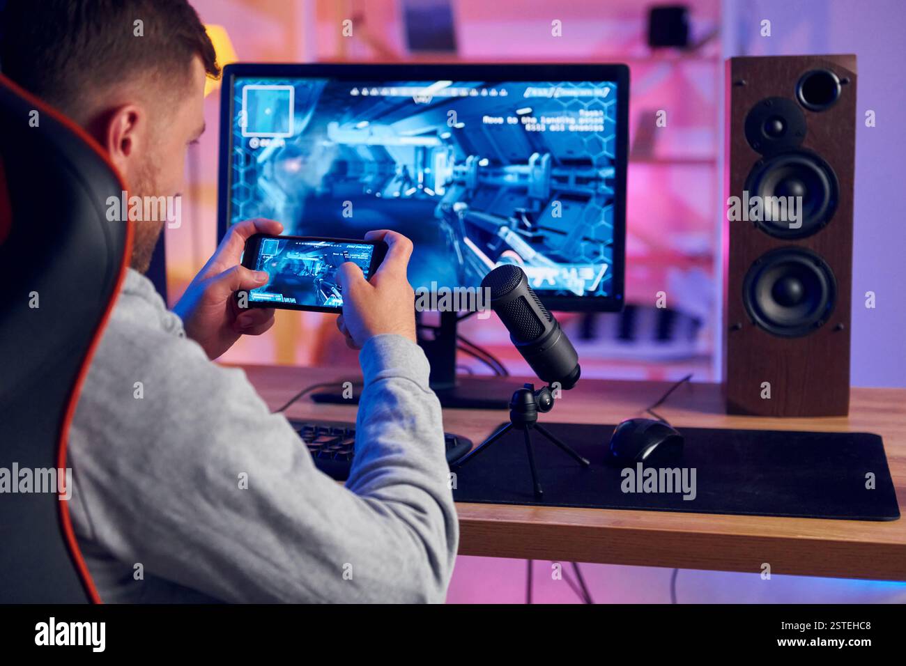 Verwenden des Smartphones. Online-Streamer, der FPS-Shooter zu Hause spielt. Stockfoto