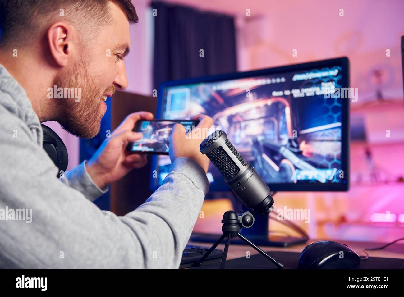 Verwenden des Smartphones. Online-Streamer, der FPS-Shooter zu Hause spielt. Stockfoto