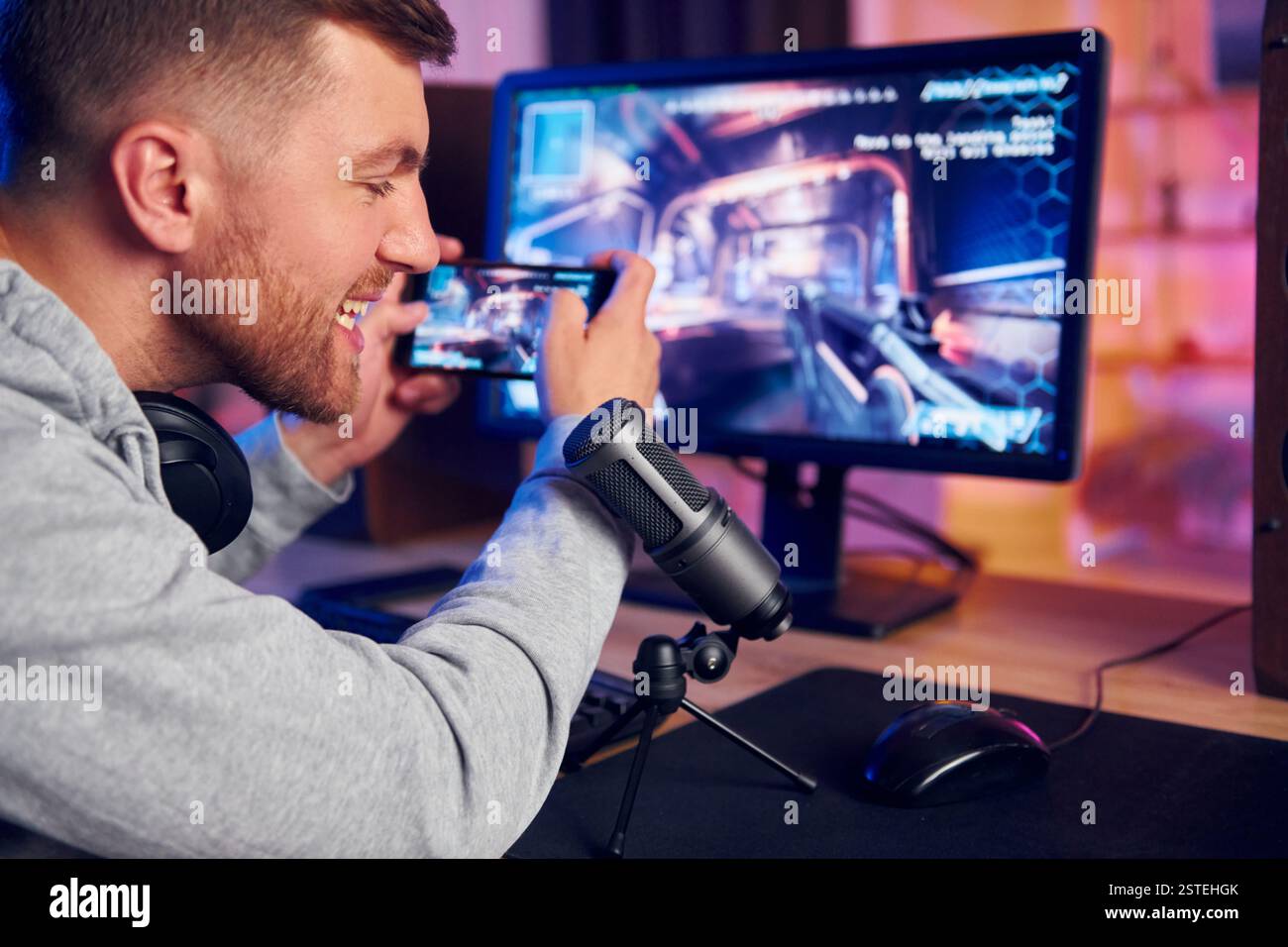 Verwenden des Smartphones. Online-Streamer, der FPS-Shooter zu Hause spielt. Stockfoto