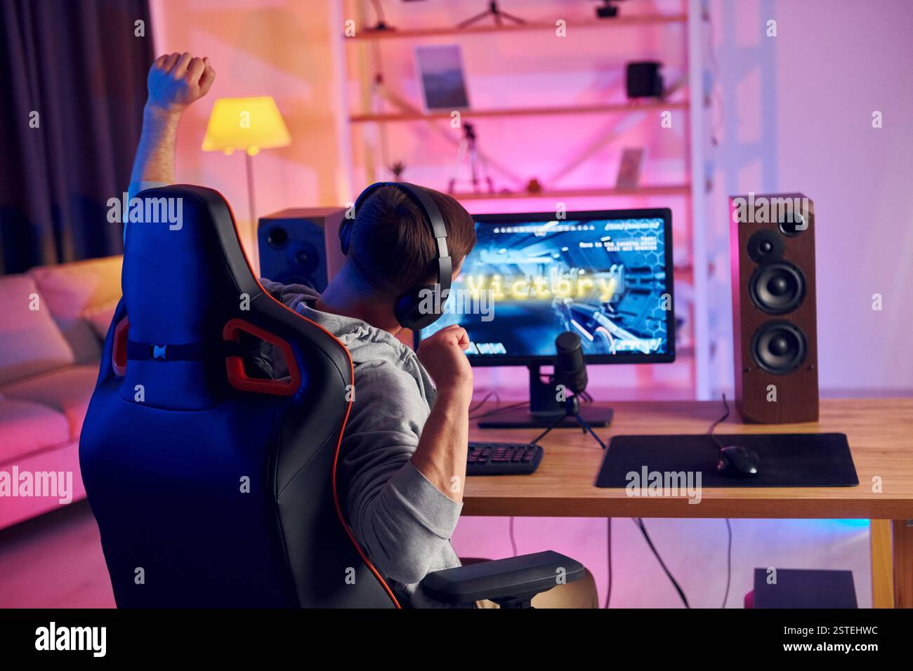 Rückansicht. Online-Streamer, der FPS-Shooter zu Hause spielt. Stockfoto