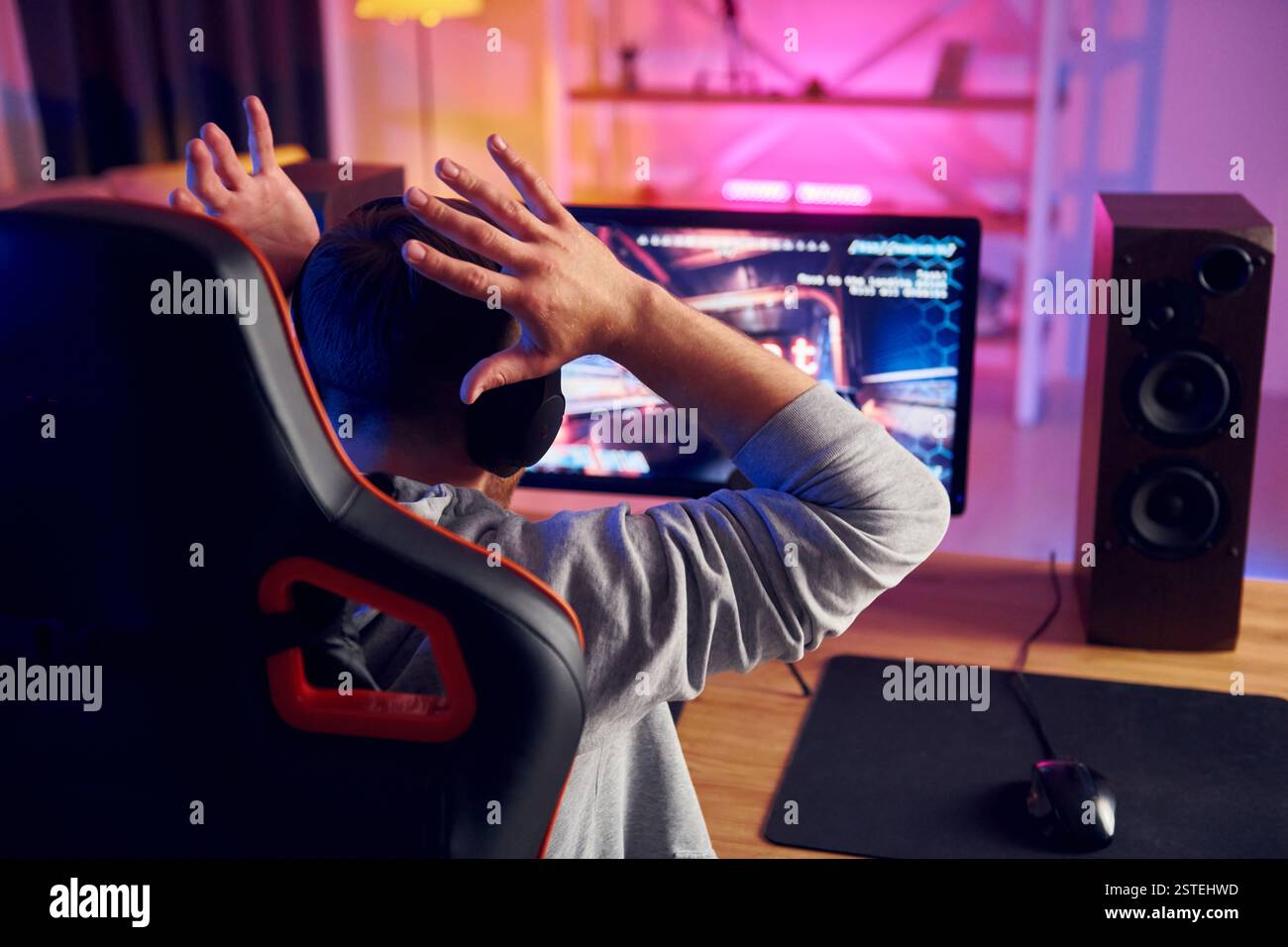Rückansicht. Online-Streamer, der FPS-Shooter zu Hause spielt. Stockfoto