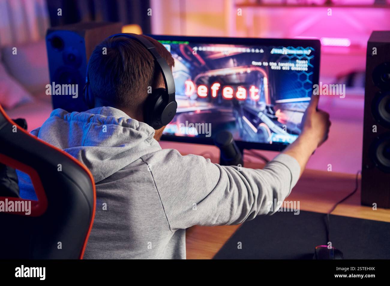 Rückansicht. Online-Streamer, der FPS-Shooter zu Hause spielt. Stockfoto