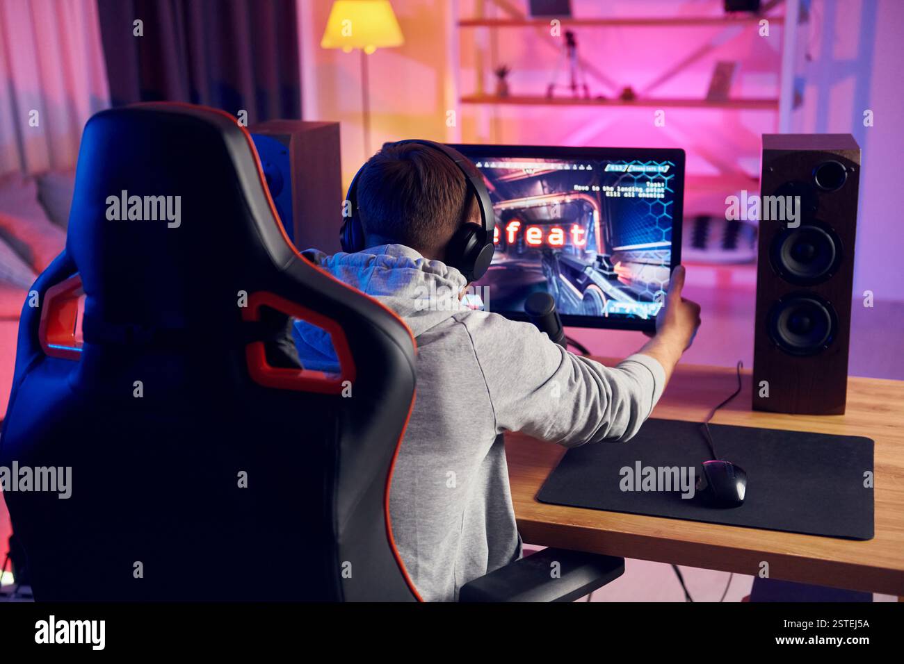 Rückansicht. Online-Streamer, der FPS-Shooter zu Hause spielt. Stockfoto