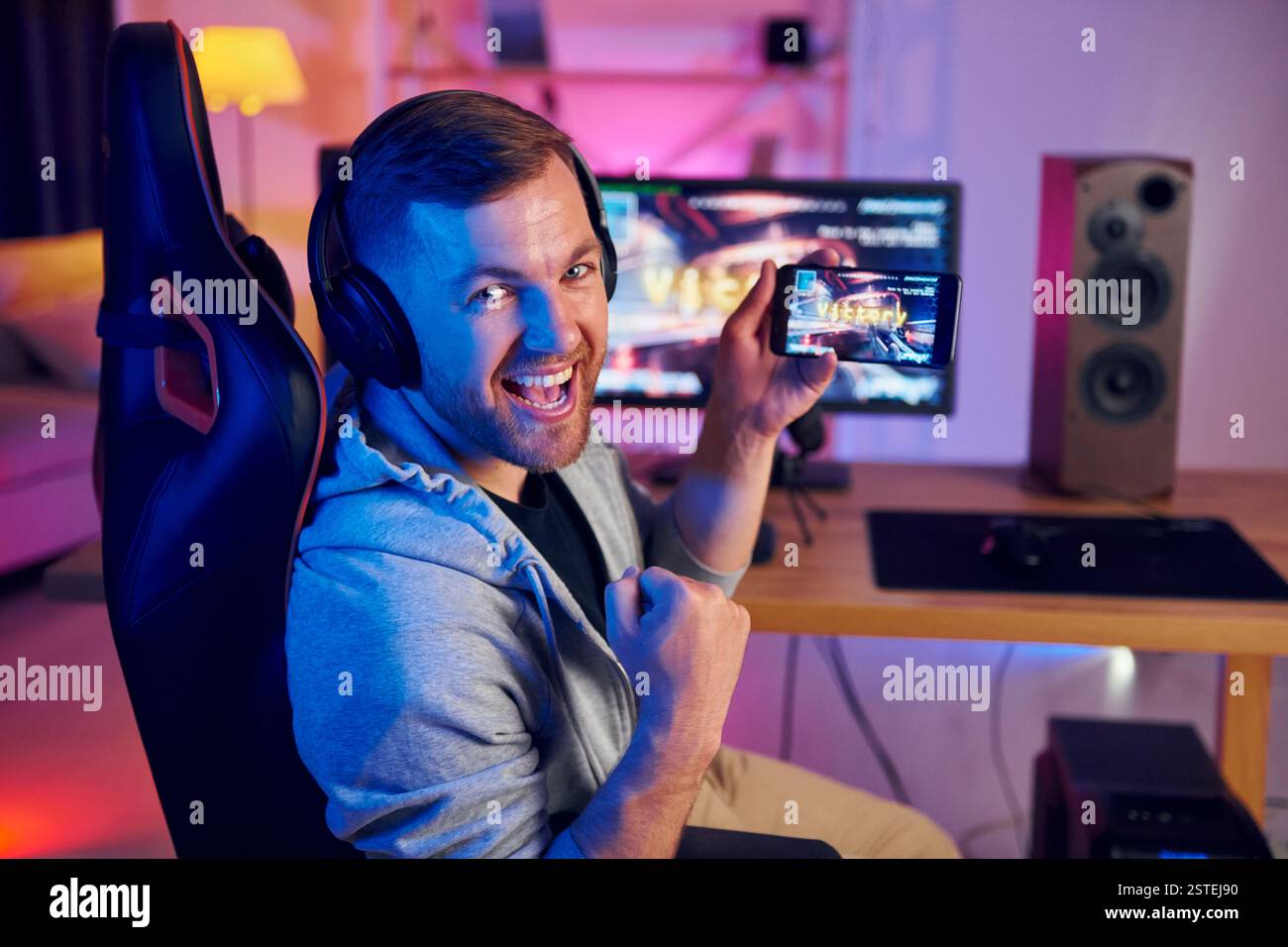 Zeigt den Sieg, der auf dem Bildschirm des Displays und des Telefons angezeigt wird. Online-Streamer, der FPS-Shooter zu Hause spielt. Stockfoto