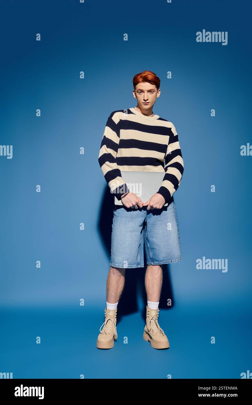 Ein junger und gutaussehender Mann steht selbstbewusst und zeigt sein stilvolles Outfit und seine emotionale Tiefe. Stockfoto