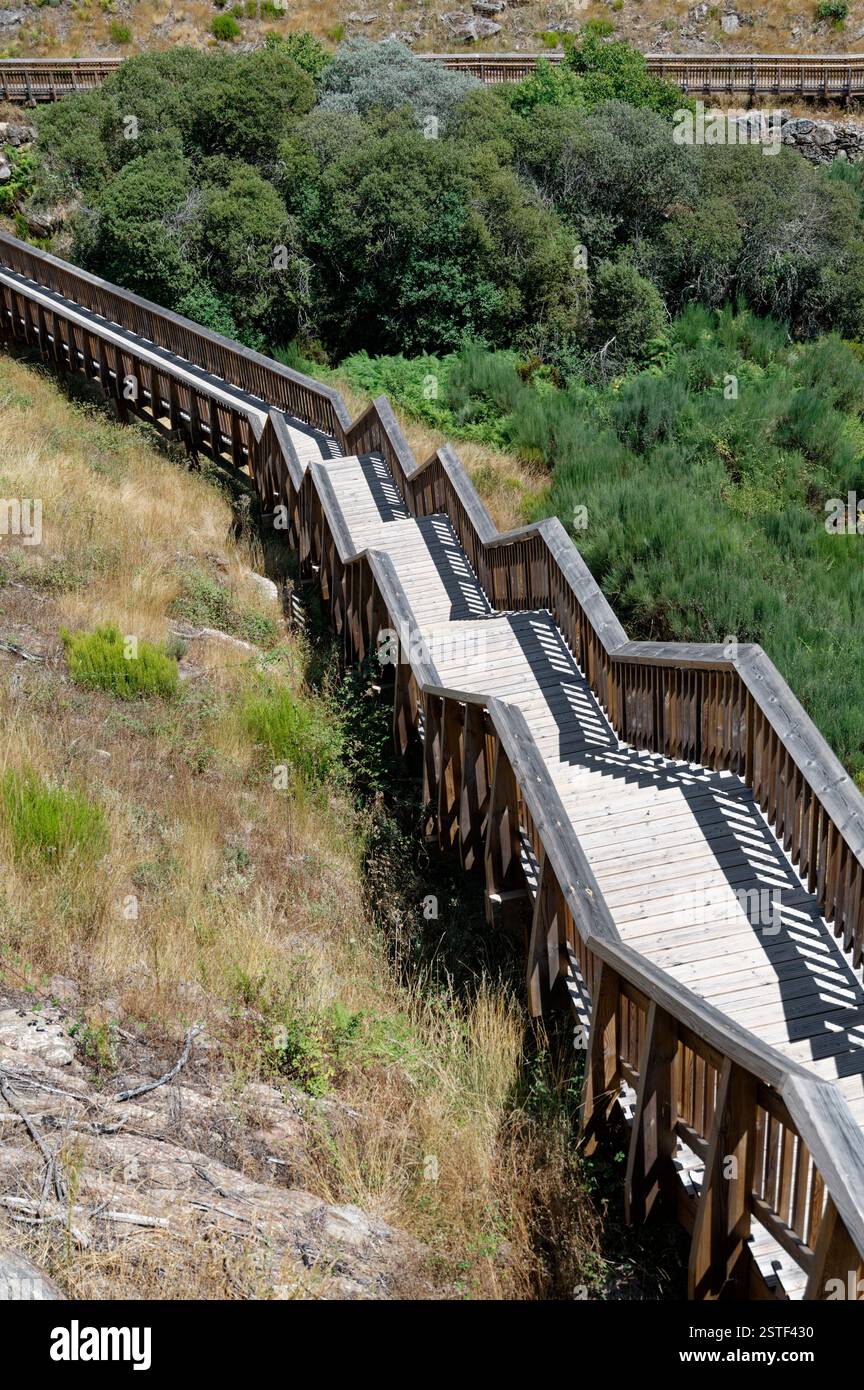 Zickzackiger Holzsteg schlängelt sich durch die zerklüftete Landschaft der Mondego Walkways Stockfoto