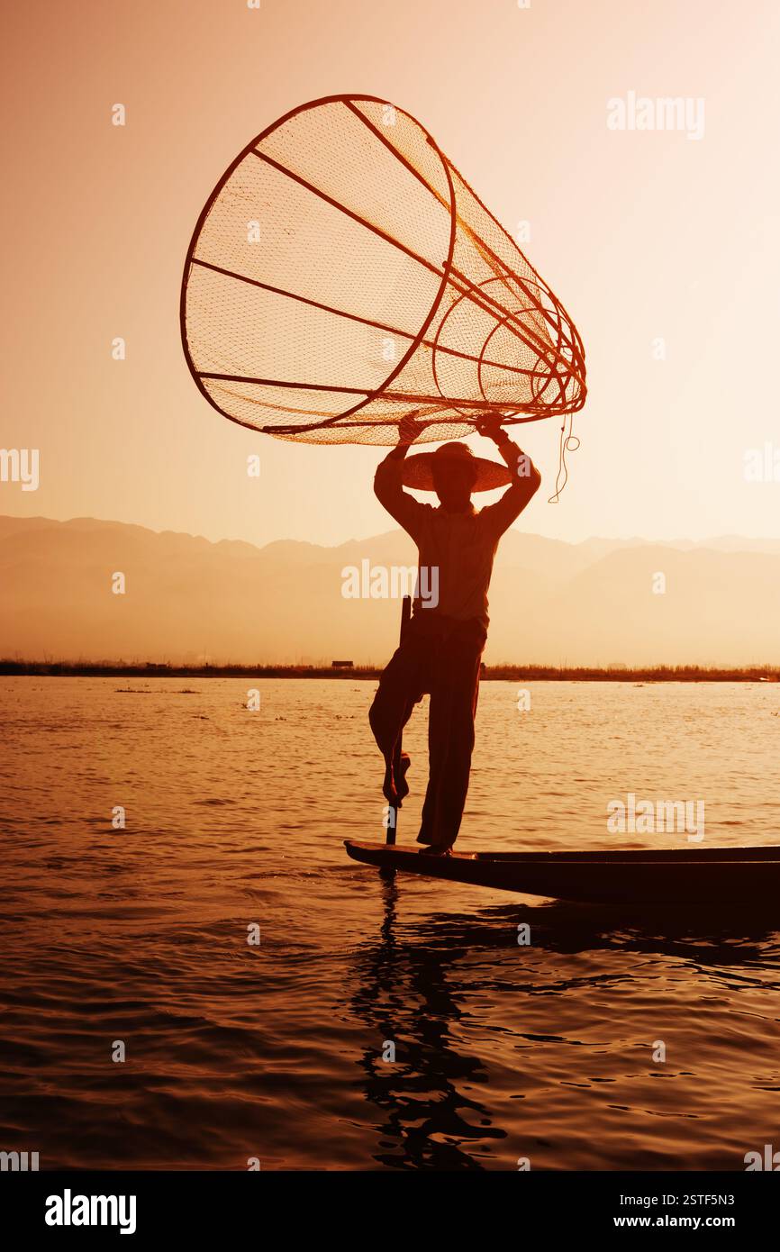 Ein lokaler Fischer, der eine Fischfalle in Inle Lake, Myanmar, platziert Stockfoto