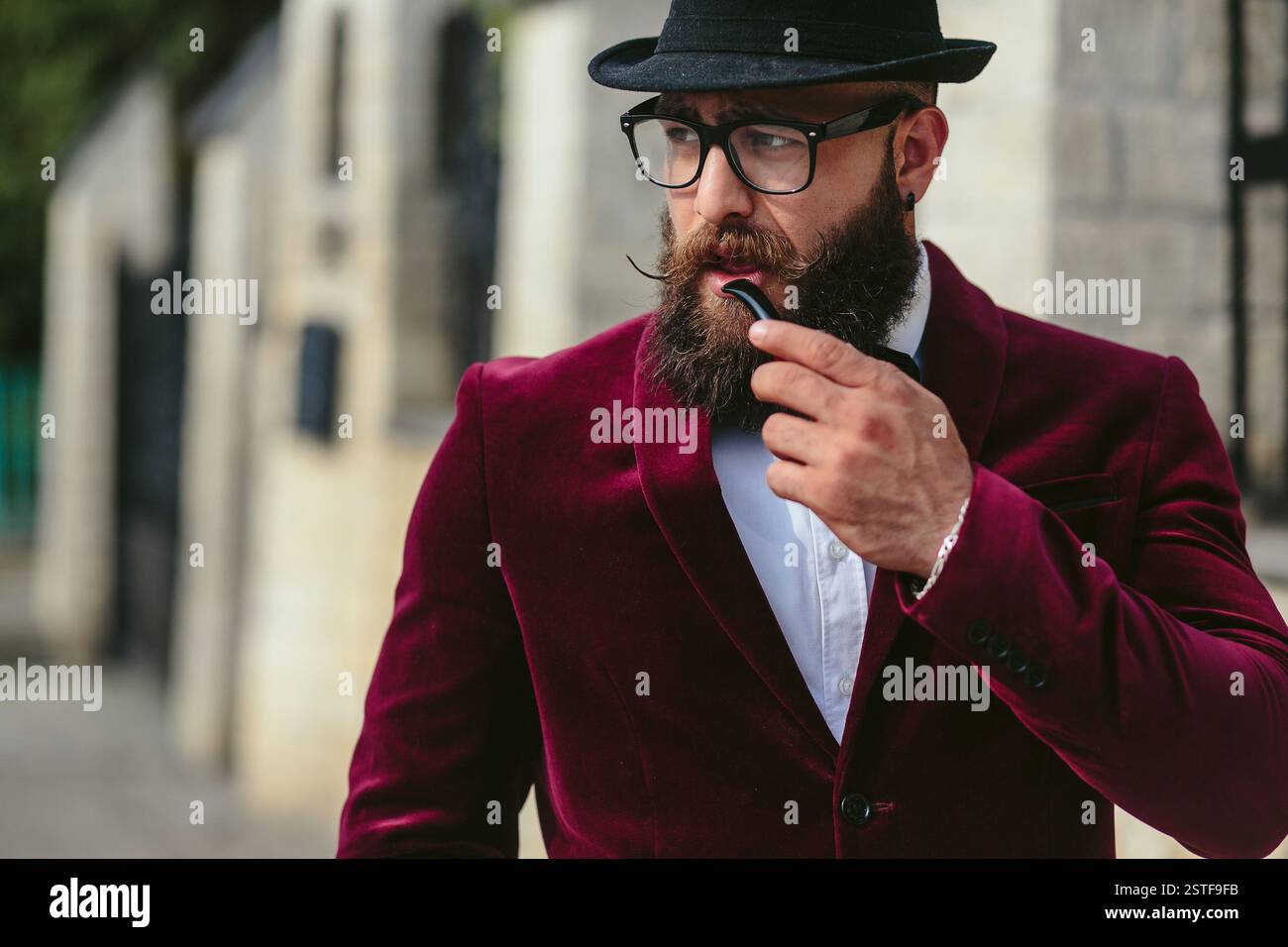 Reicher Mann in einer Jacke in der Nähe seines Hauses Stockfoto