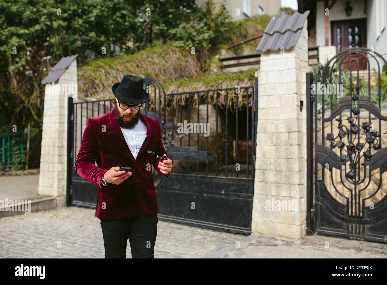 Reicher Mann in einer Jacke in der Nähe seines Hauses Stockfoto